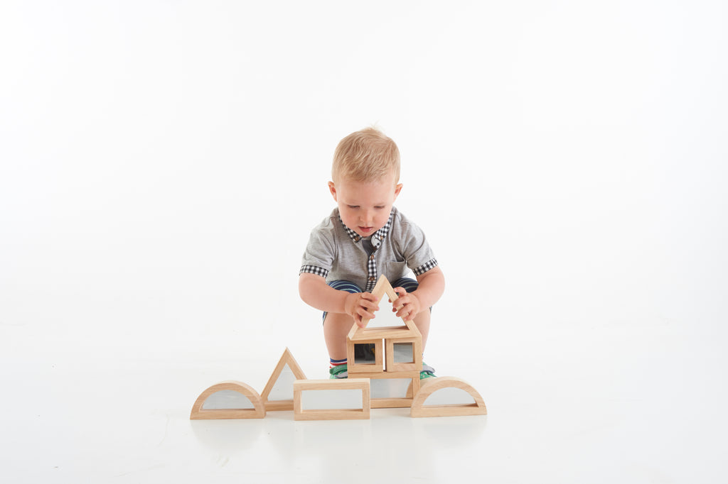Wooden mirror blocks set with arched openings and triangular pieces, shown assembled
