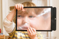 Black rectangular sheet magnifier held by a child, enlarging a face