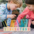 Wooden number learning board with 1–10 and colorful drinking straws for counting