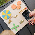 Sensory learning board with wooden gears, tic-tac-toe grid, and shape pieces