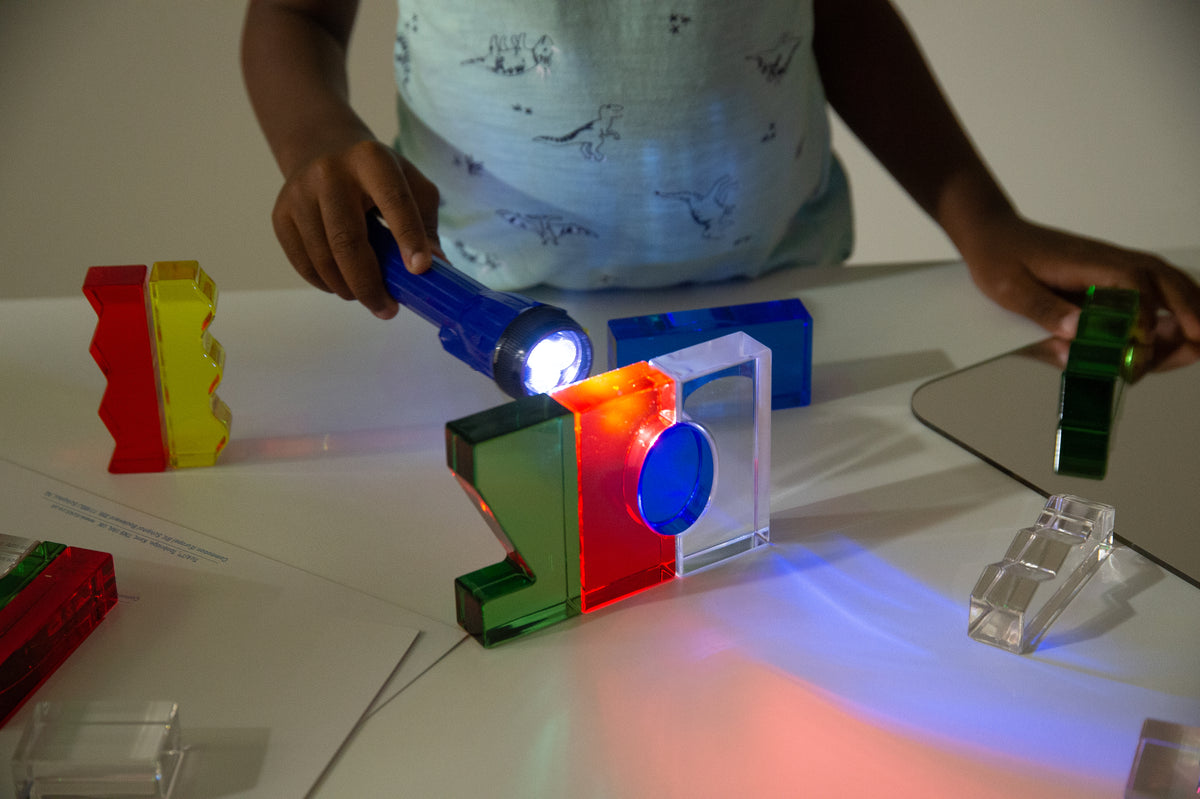 Handheld LED torch shining bright white light on colorful block display