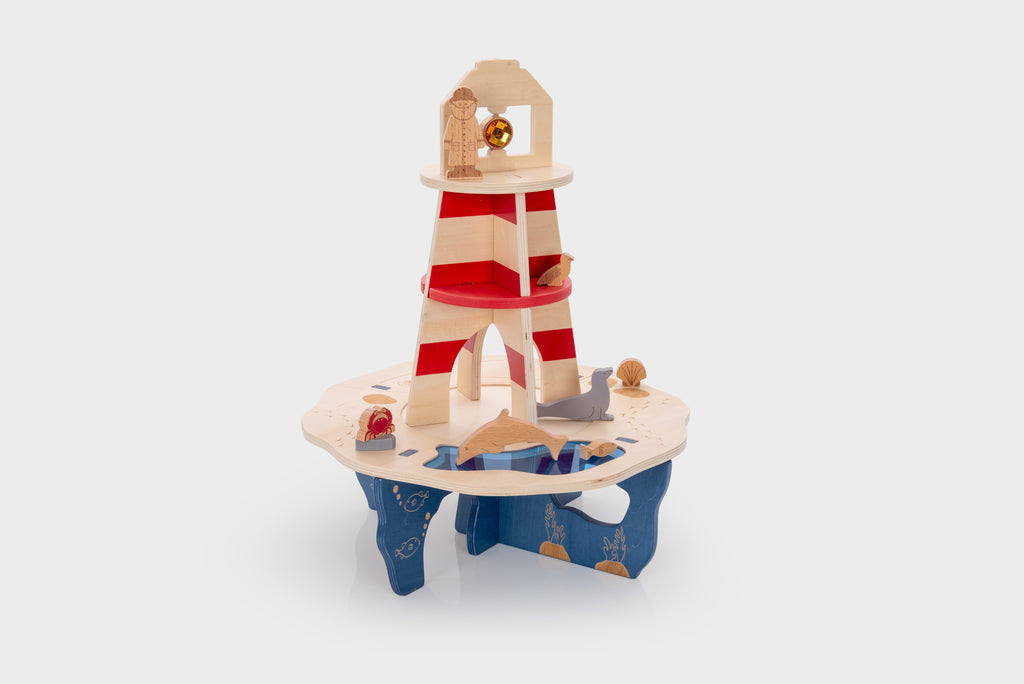 Wooden lighthouse playset with red-and-cream striped tower and circular sea-themed base