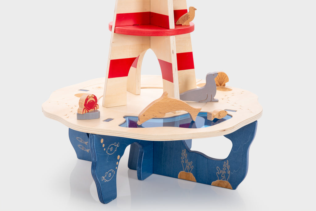 Wooden lighthouse playset with wide circular platform, sea creatures detail, striped tower