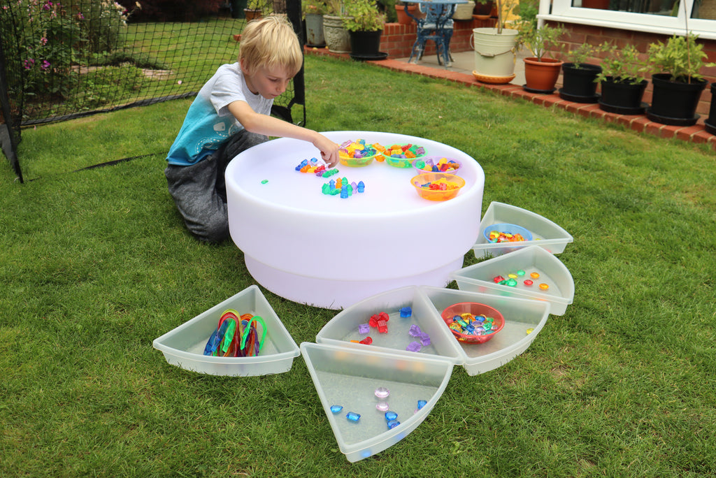 Kid playing with white bead sorting bowl and open multi-compartment tray