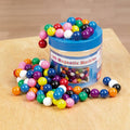 Magnetic marble toy set: blue tub with colorful magnetic marbles scattered