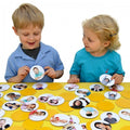 Children holding emotion face cards from a matching pairs memory game