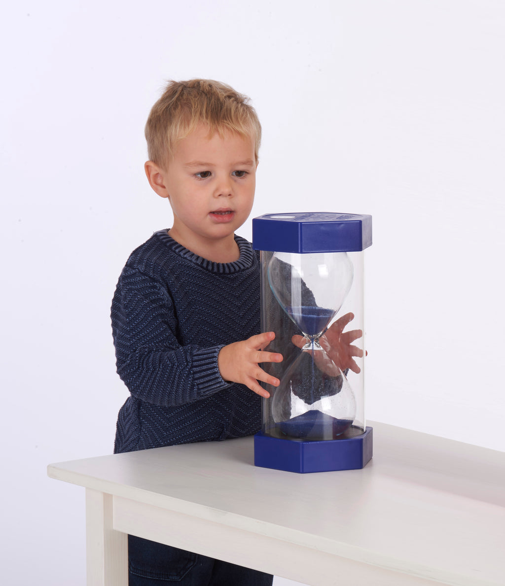 Blue 5-minute sand timer with clear glass body and hourglass shape on tabletop