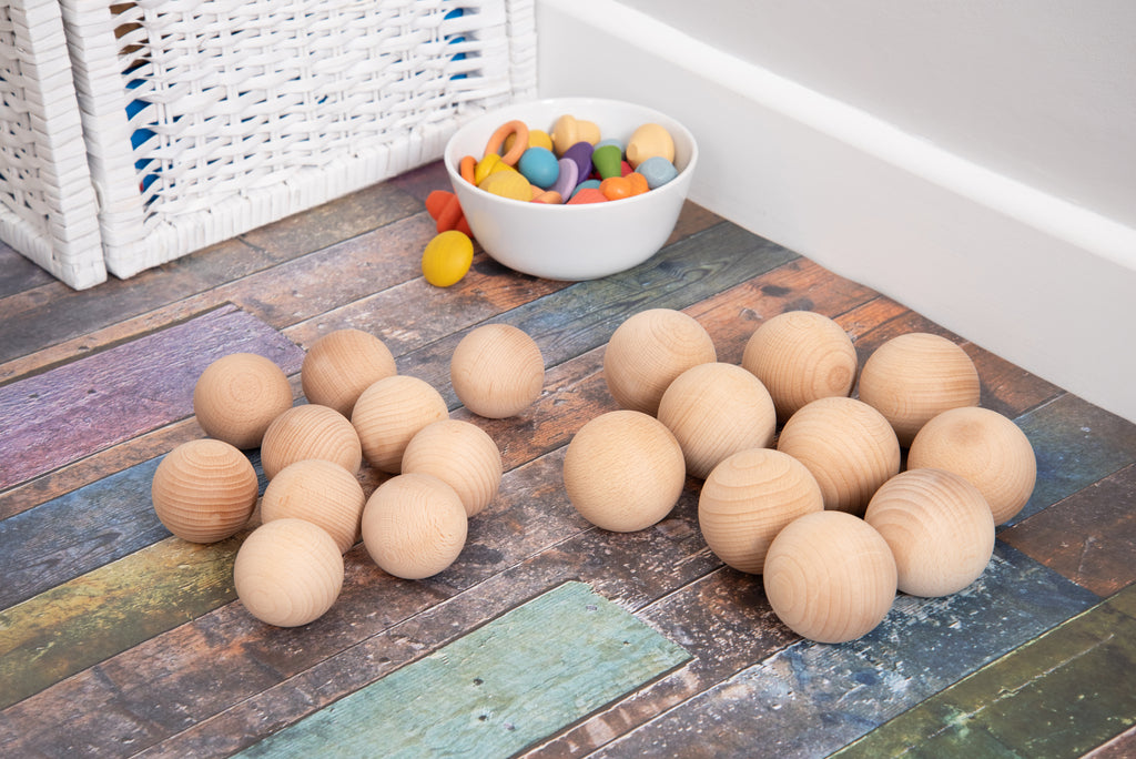 Natural wooden balls, 50mm, light wood spheres scattered for play.
