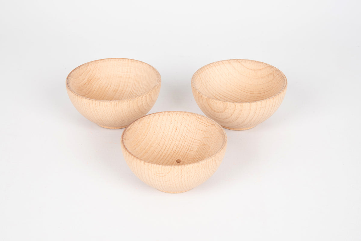 Three natural wooden bowls with smooth interiors and visible wood grain