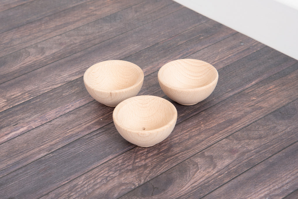 Three small natural wooden bowls with round shape and wood-grain interior