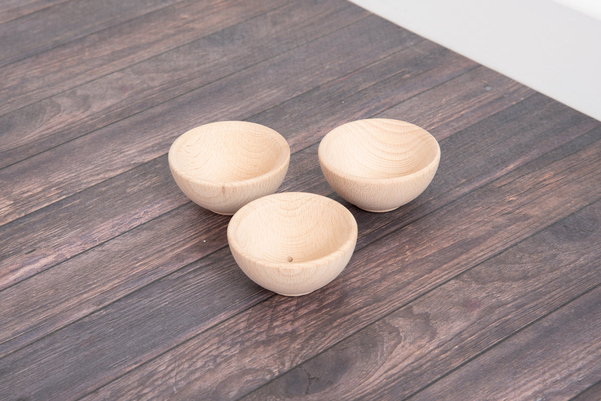 Three small natural wooden bowls with round shape and wood-grain interior