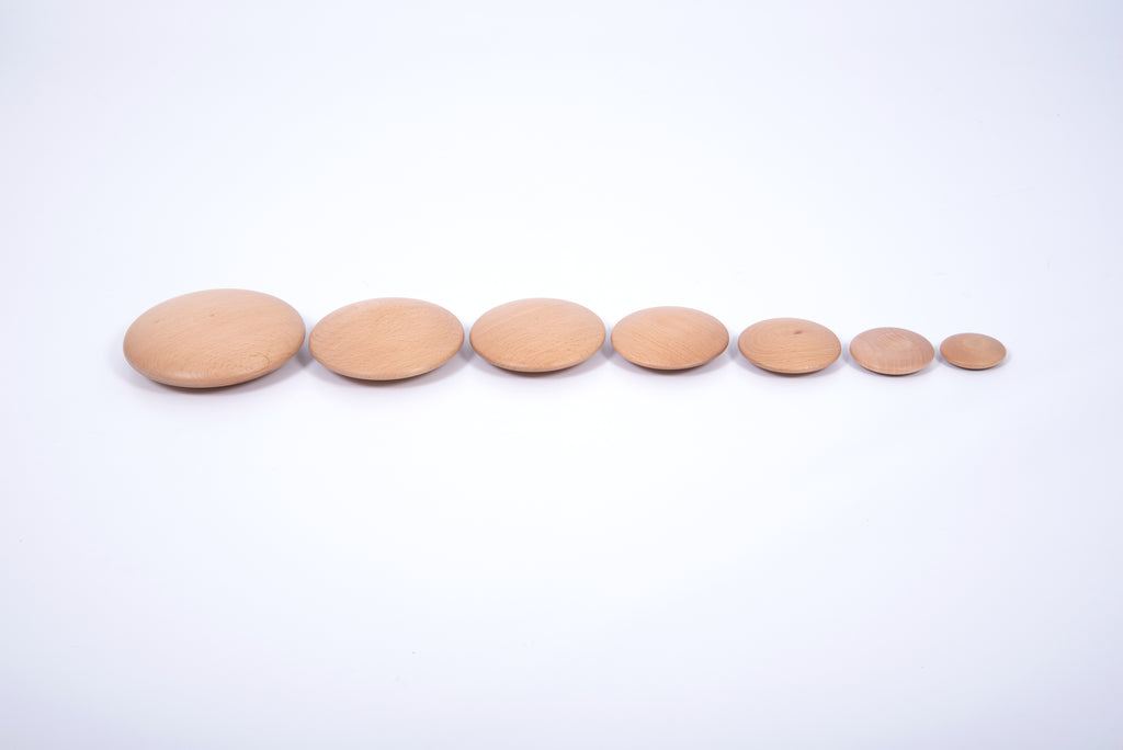 Set of 7 natural wooden buttons, light tan round discs arranged in a line