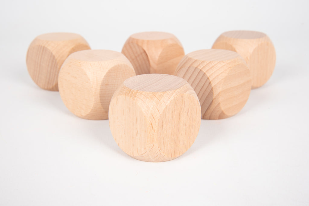 Natural light wood cube blocks with rounded edges, laid out in a loose row