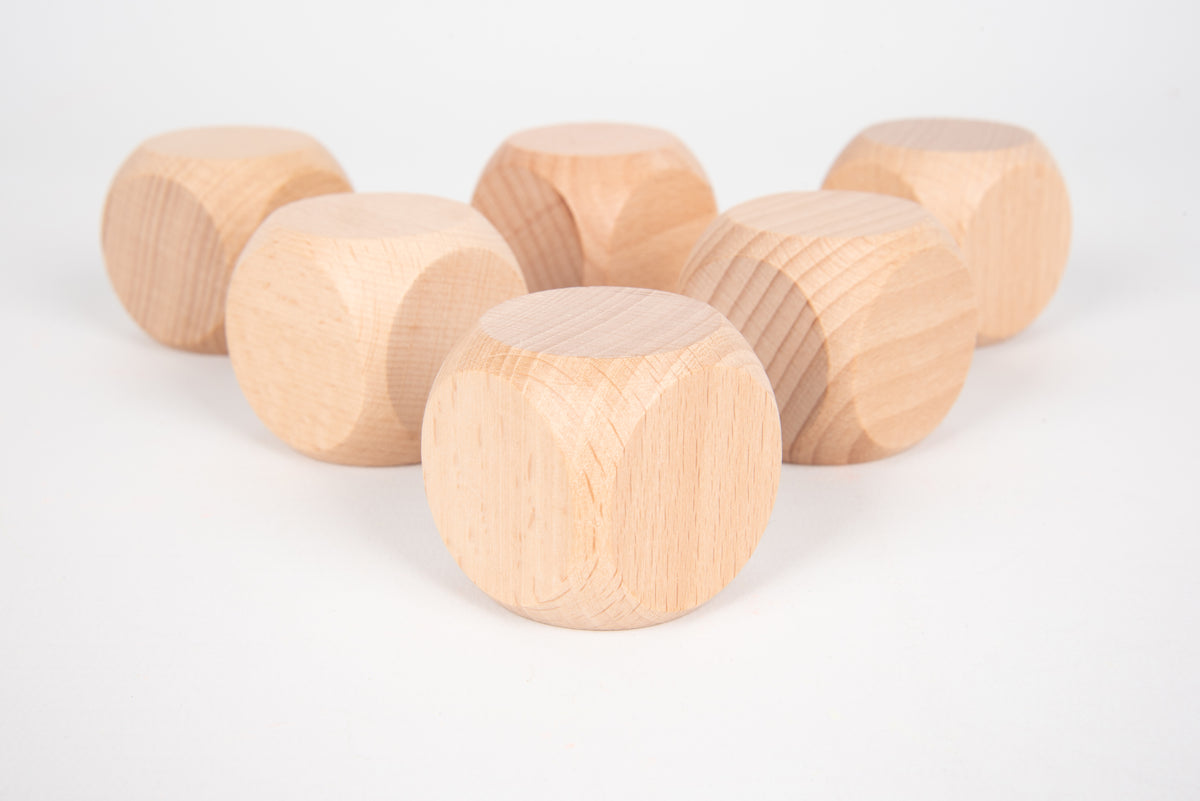 Natural light wood cube blocks with rounded edges, laid out in a loose row