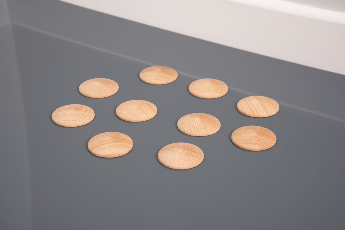 Natural wooden discs in a loose cluster, light tan ovals with parallel grooves
