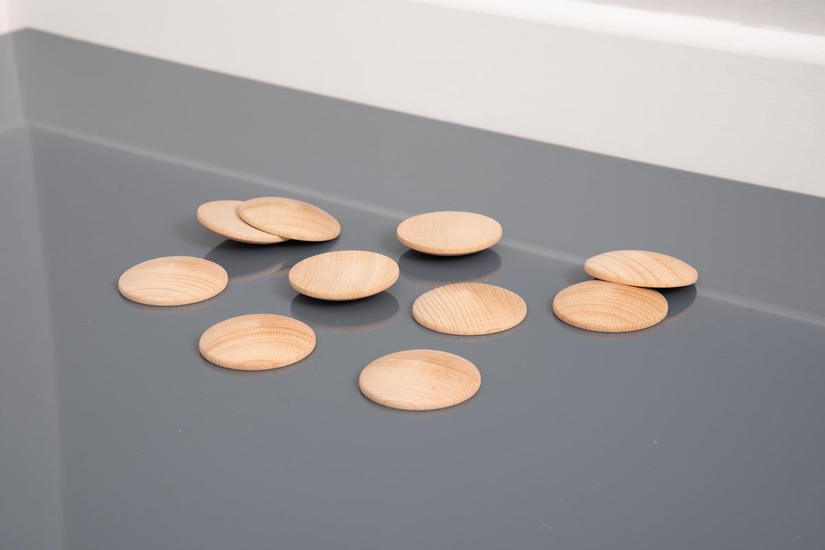 Small natural wooden discs scattered, light tan ovals with ridged wood grain