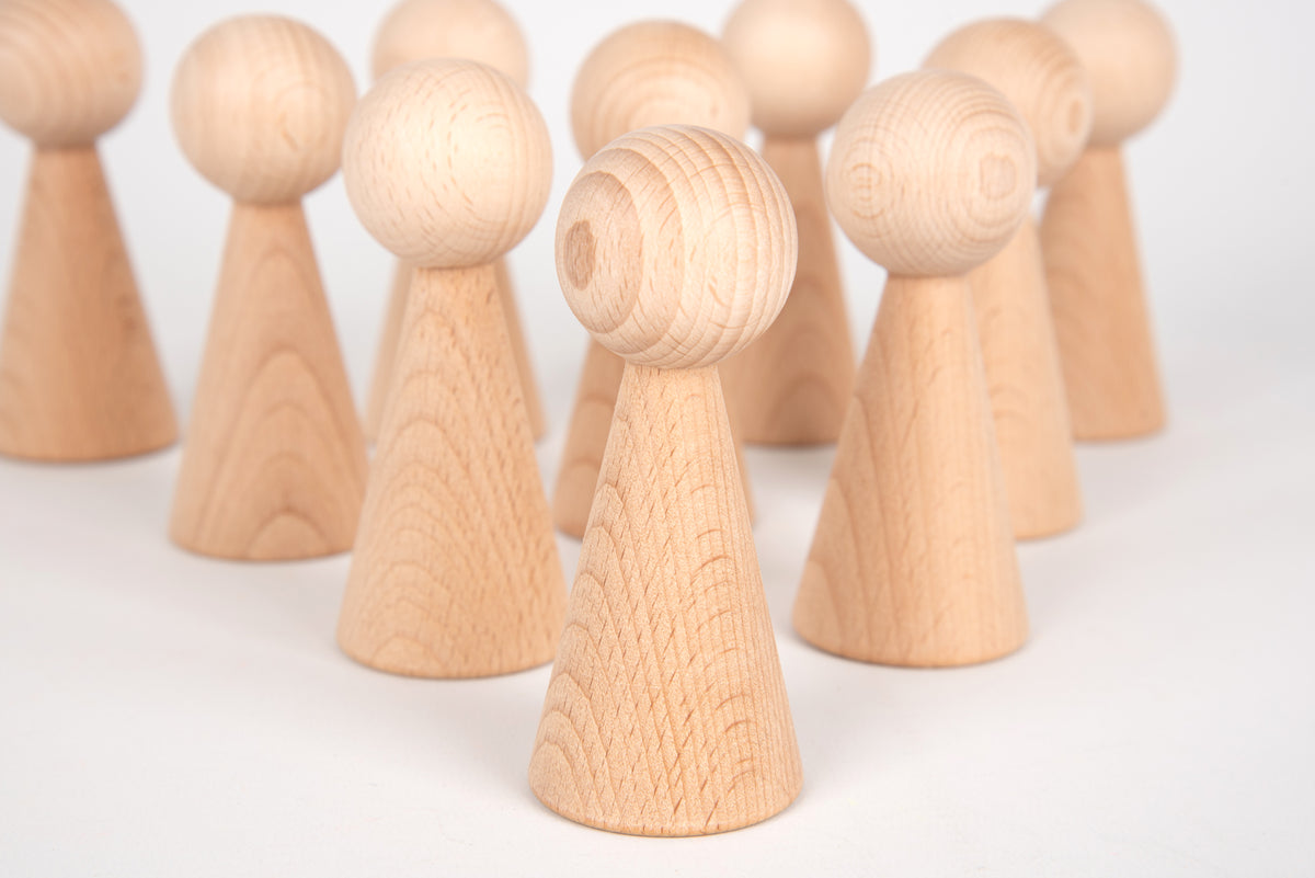 Close-up of natural wood peg figures with rounded heads and carved neck details