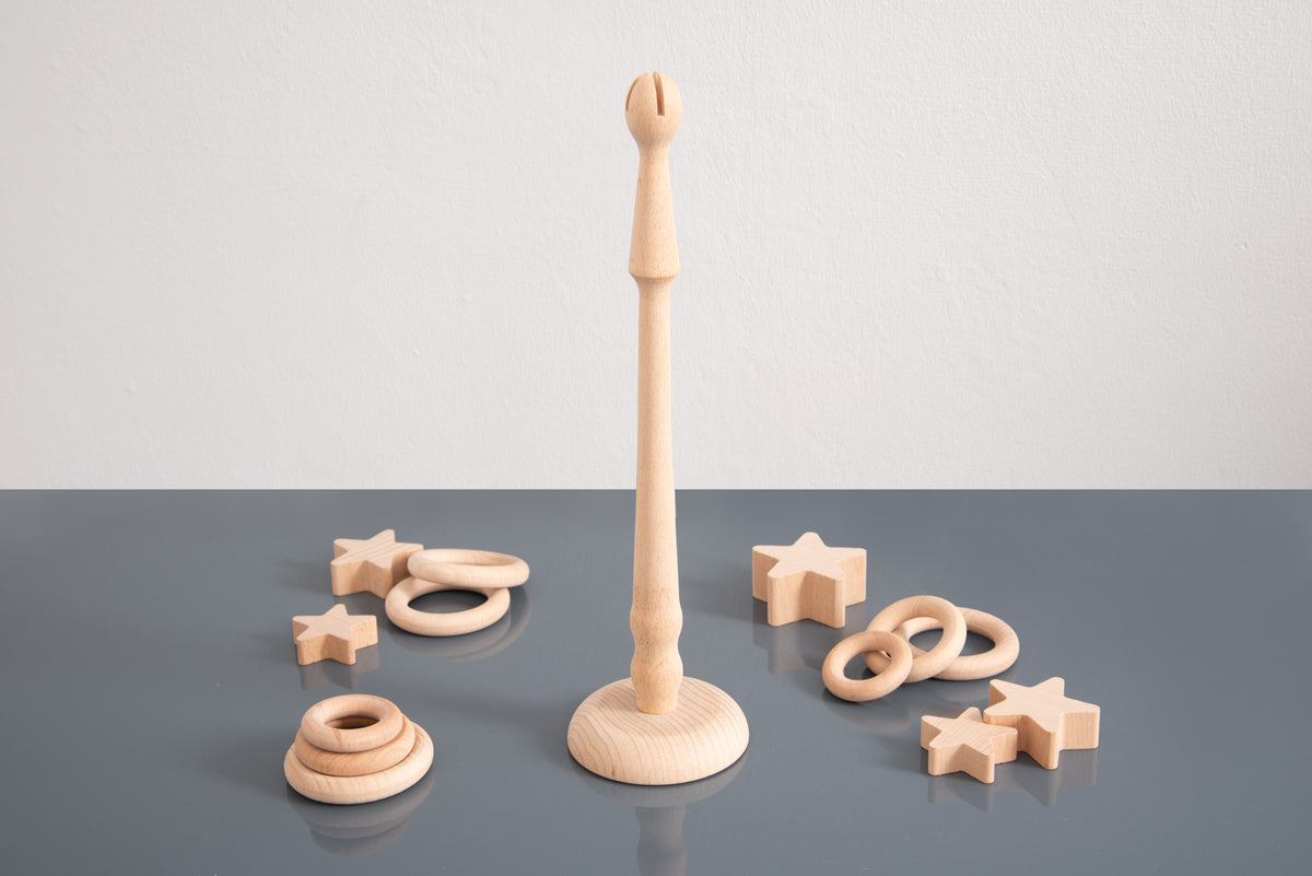 Light wooden ring stand on round base with ring loops and star ornaments arranged around it