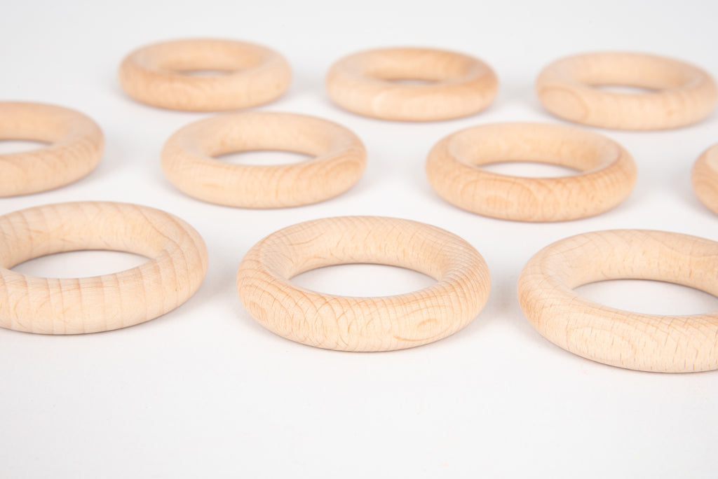 Natural wooden rings, light wood 56 mm o-rings lying in a loose cluster