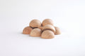 Natural wooden semispheres, light tan domed pieces piled together