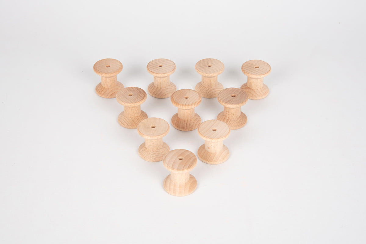Natural wooden thread spools in a small pyramid-like pile, tops facing upward.