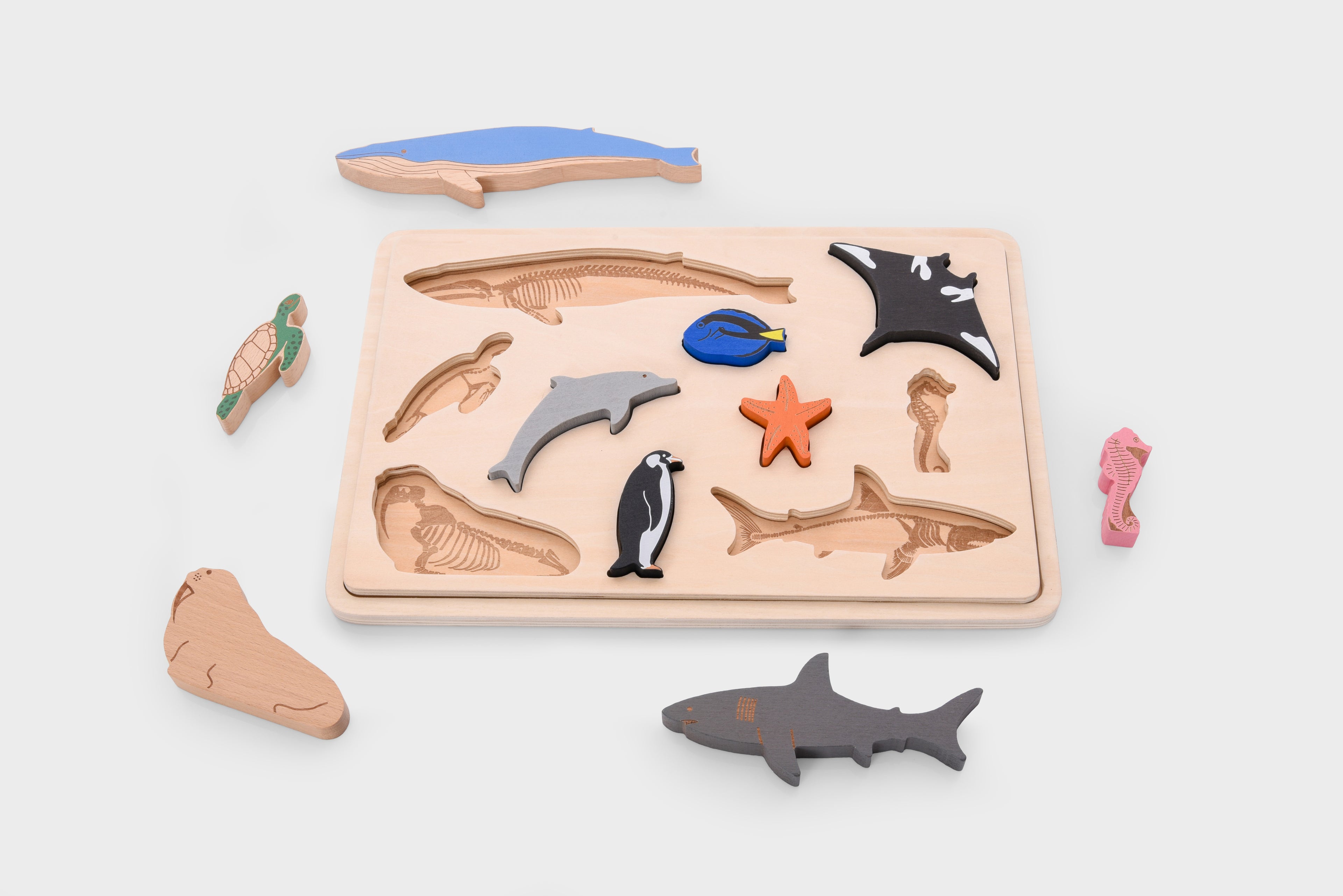Wooden ocean animal layer puzzle base with layered fish and shark pieces plus orange starfish cutout.