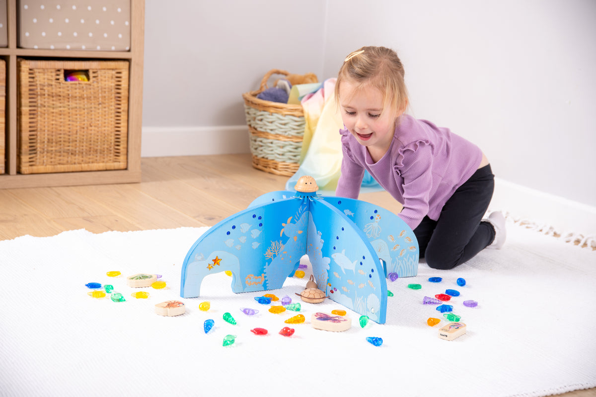 Blue arched ocean play divider with central opening and cutout dot pattern