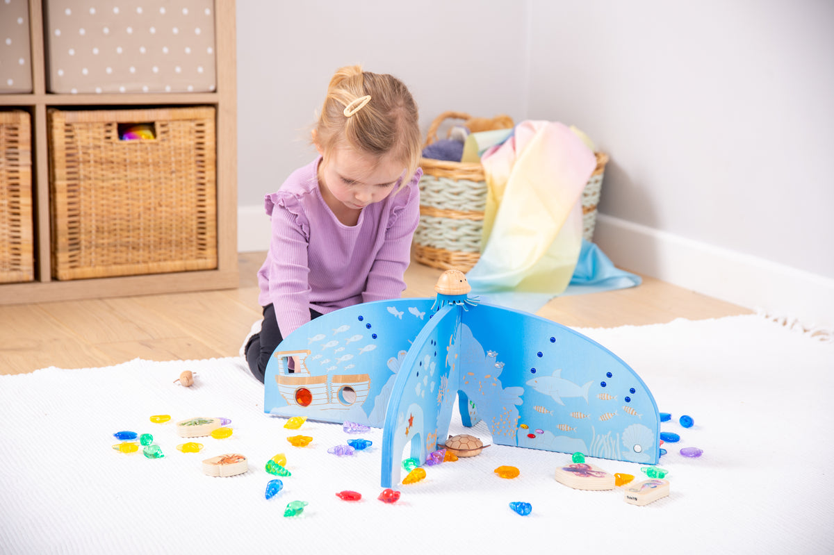 Blue ocean play divider with arched screen and cutout sea graphics