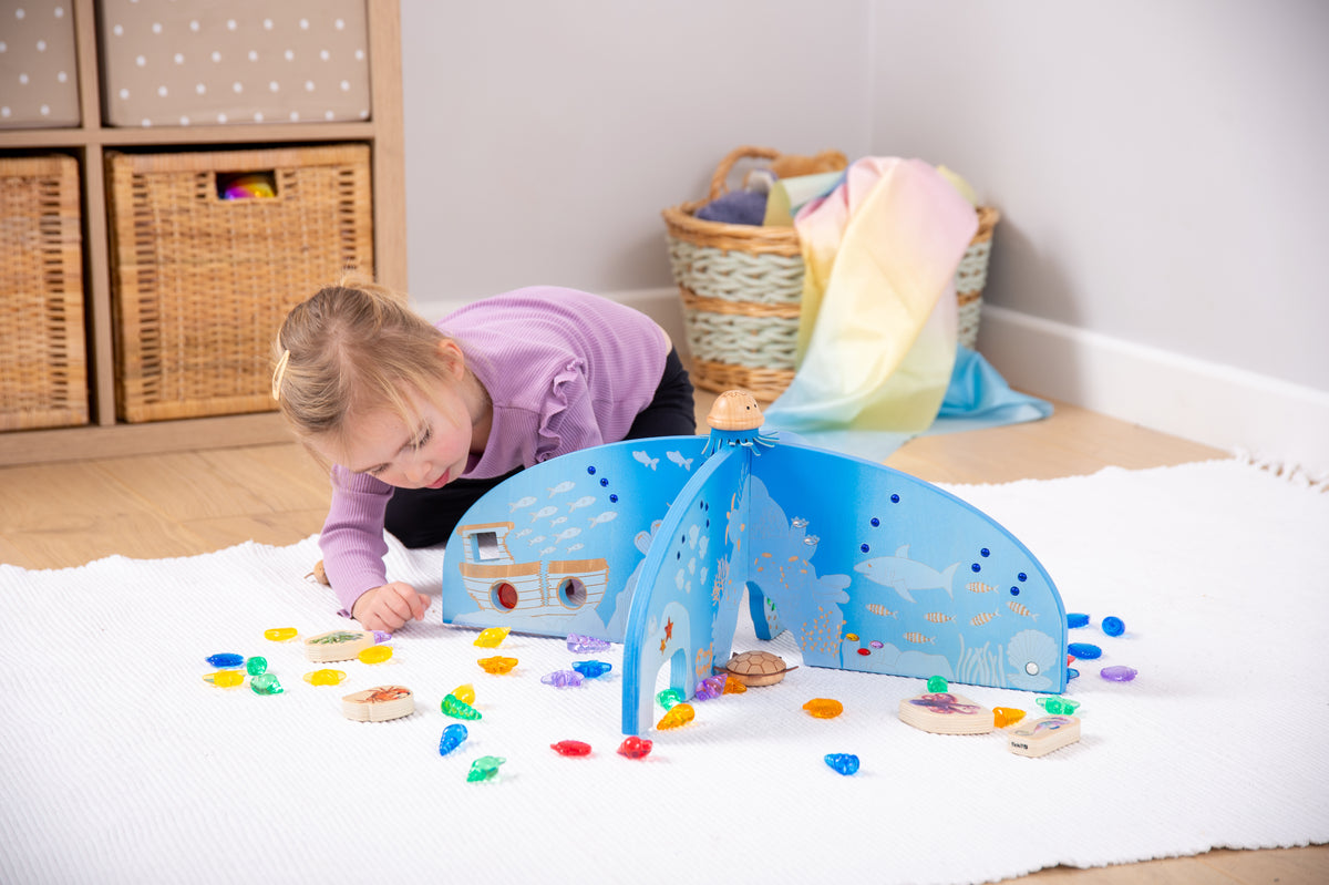 Blue arched ocean play divider with cutout sea scenes and central stand