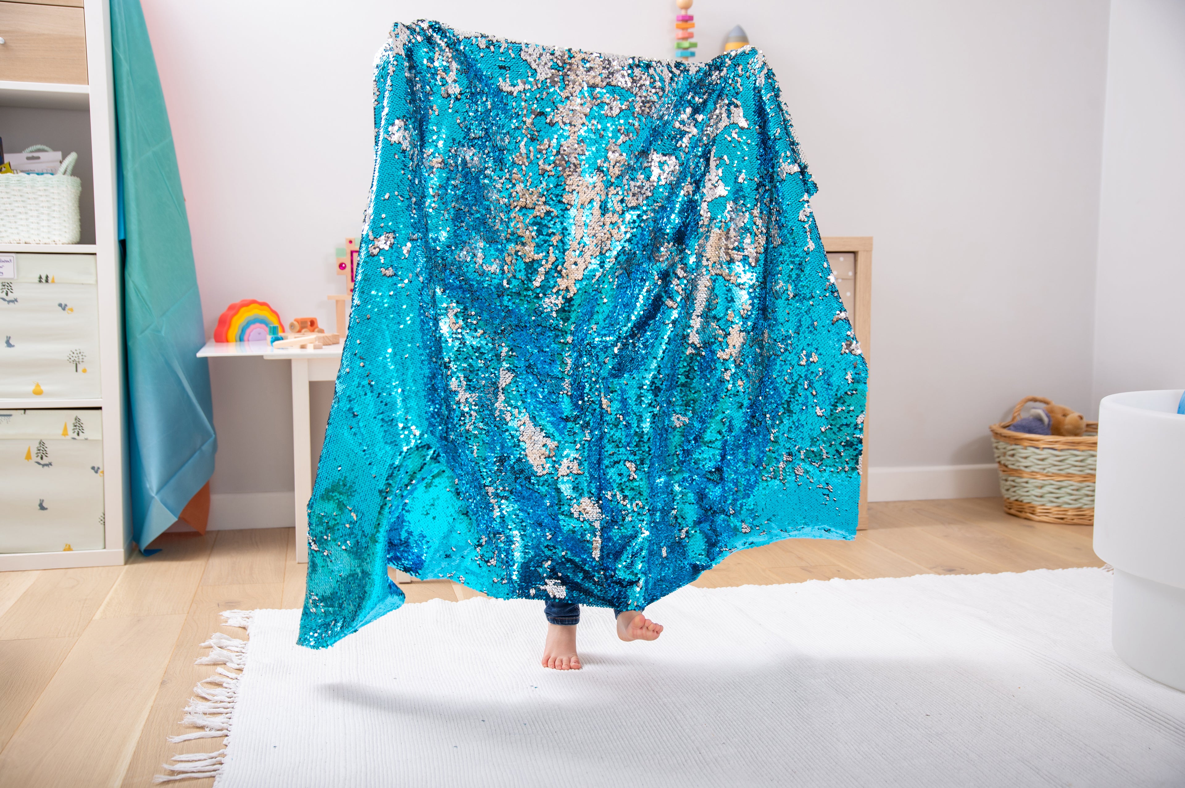 Blue sequin fabric draped blanket with sparkly, uneven shimmer pattern