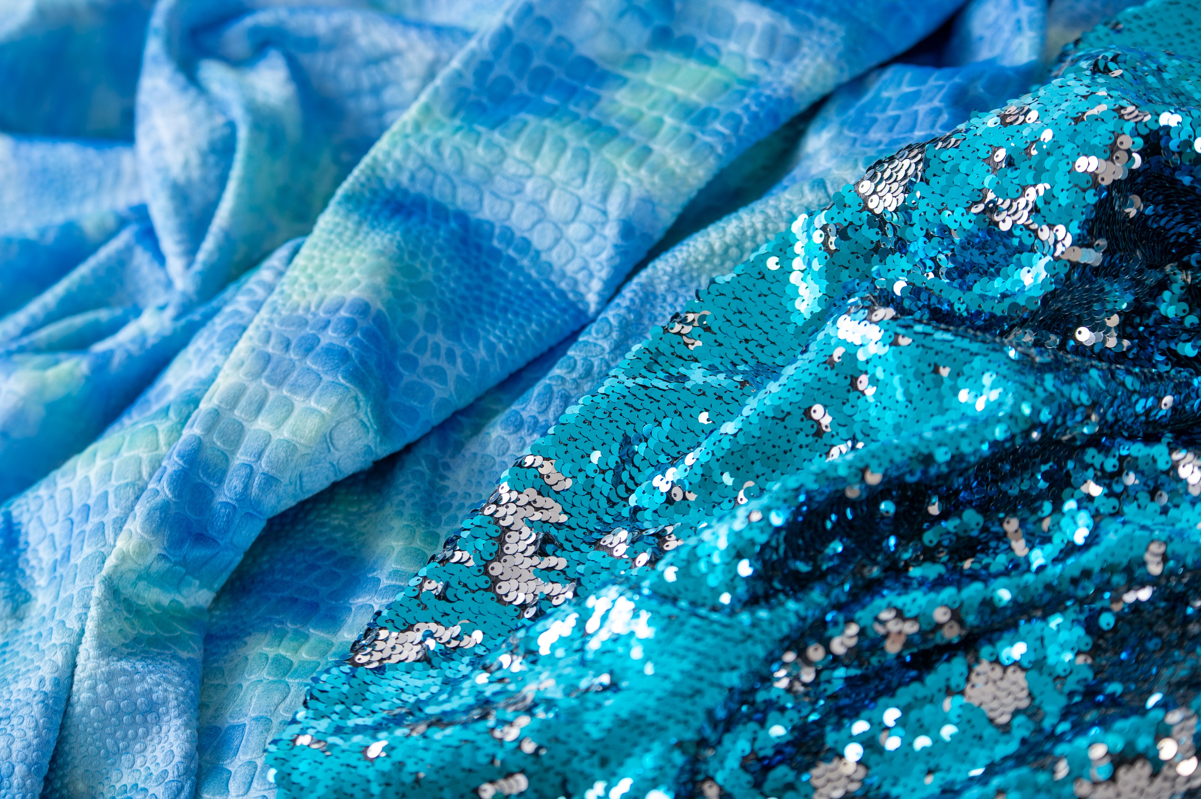 Close-up of blue sequin fabric with silver glitter-like shimmer
