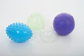 Sensory balls close-up: blue spiky, white speckled, light green and purple smooth