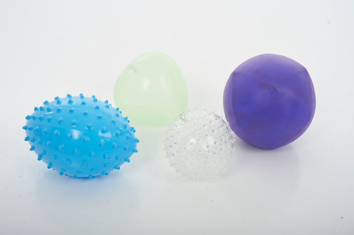 Sensory balls close-up: blue spiky, white speckled, light green and purple smooth