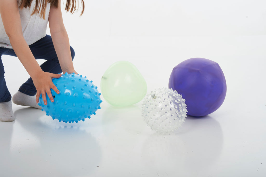 Sensory balls close-up: blue spiky, white speckled, light green and purple smooth