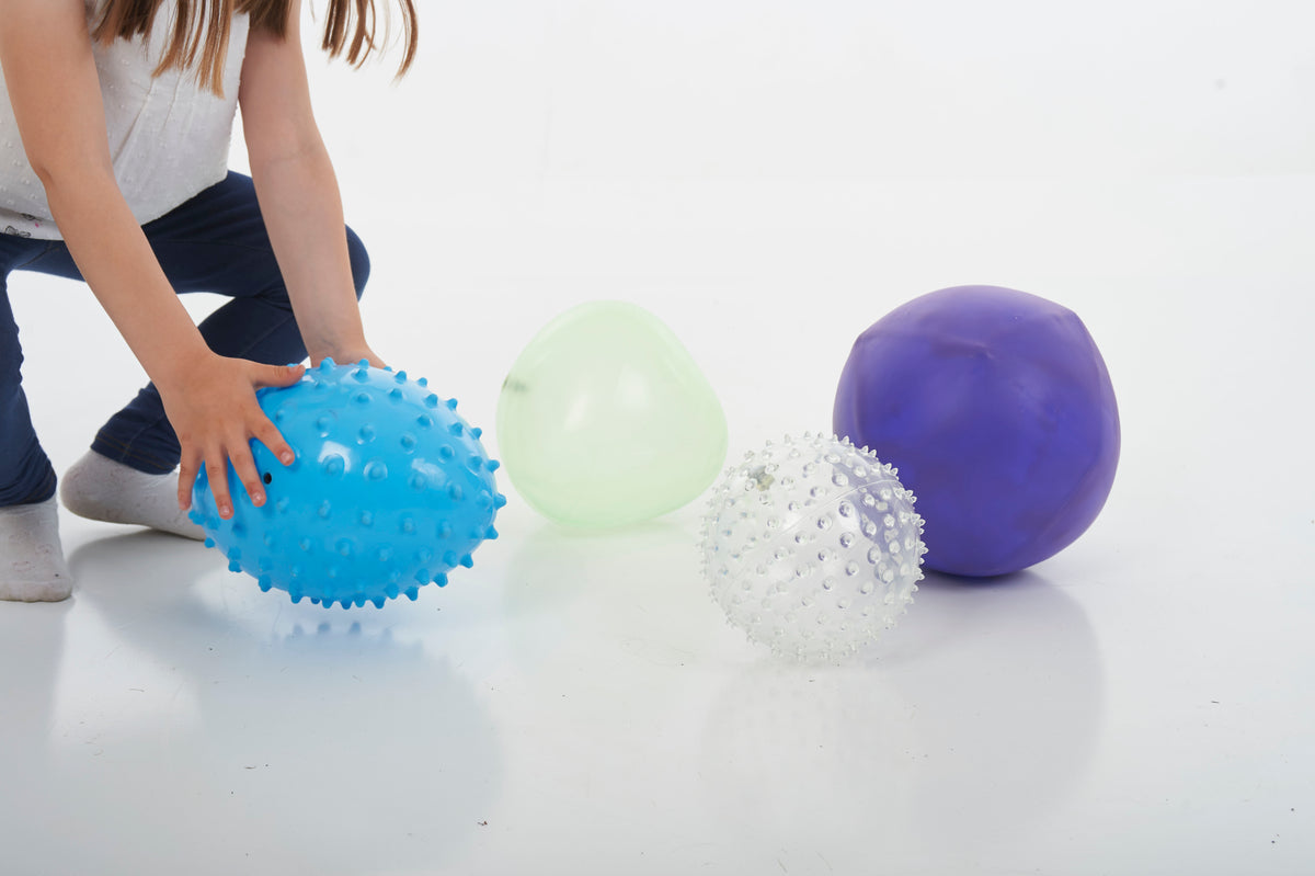 Sensory balls close-up: blue spiky, white speckled, light green and purple smooth