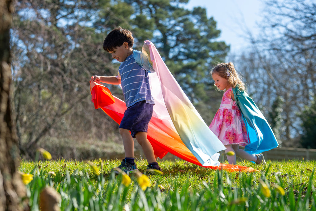 Ombre fabric ribbon scarf in red, pink, and blue, held by two children outdoors