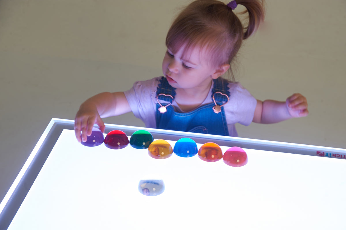 Set of 8 colorful light-up hemispheres on a glowing tray