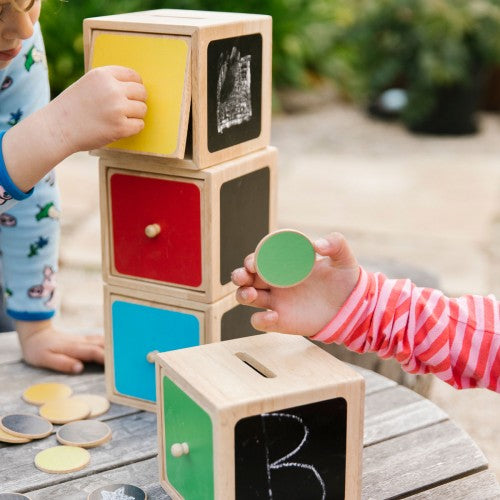 Wooden shape-sorting activity toy with stacked cubes and colorful panels