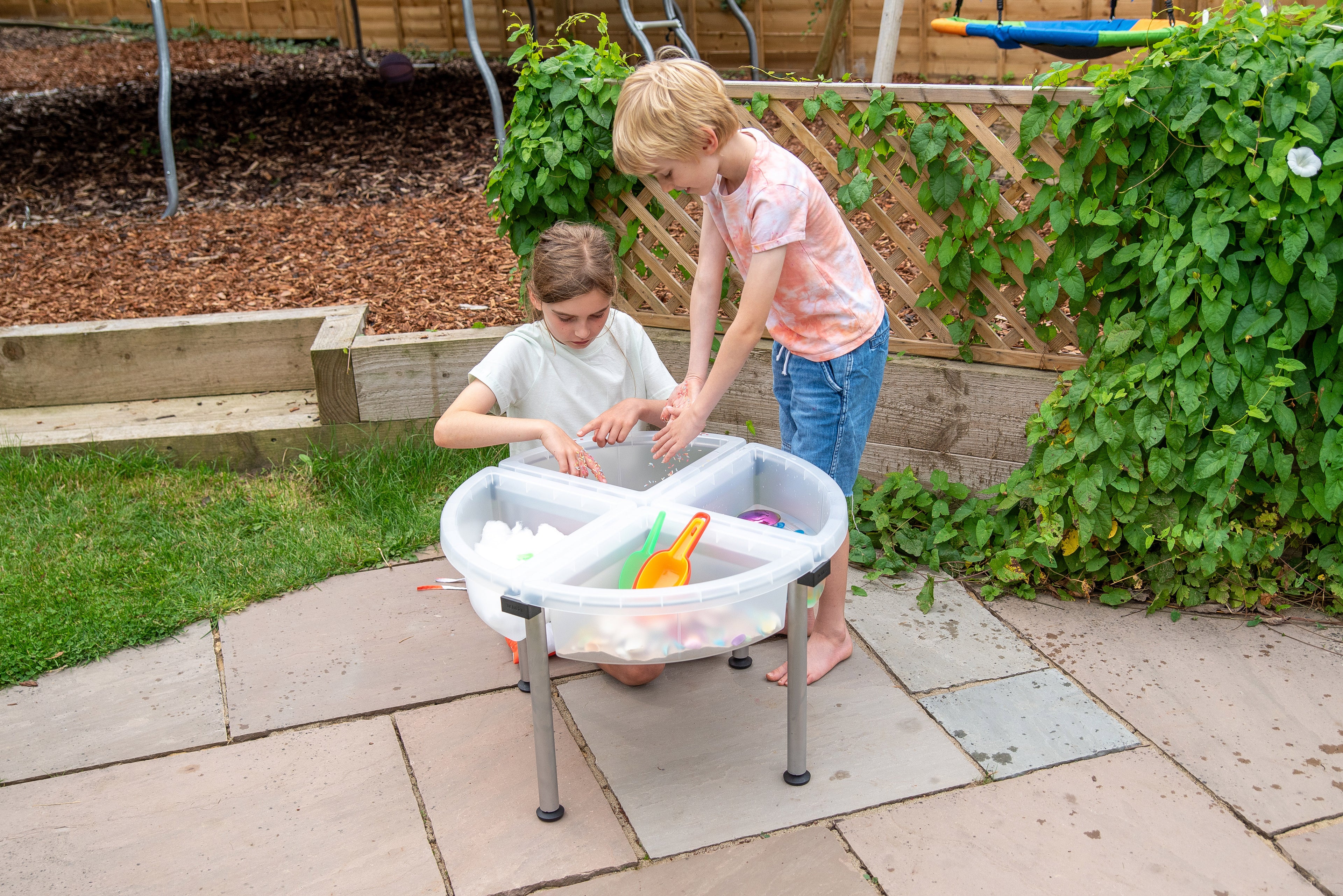 Four-compartment clear plastic tray on metal stand in use