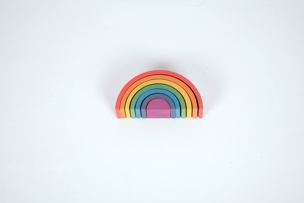 Small rainbow arch toy with layered curved arcs in red, orange, yellow, green, blue, and purple