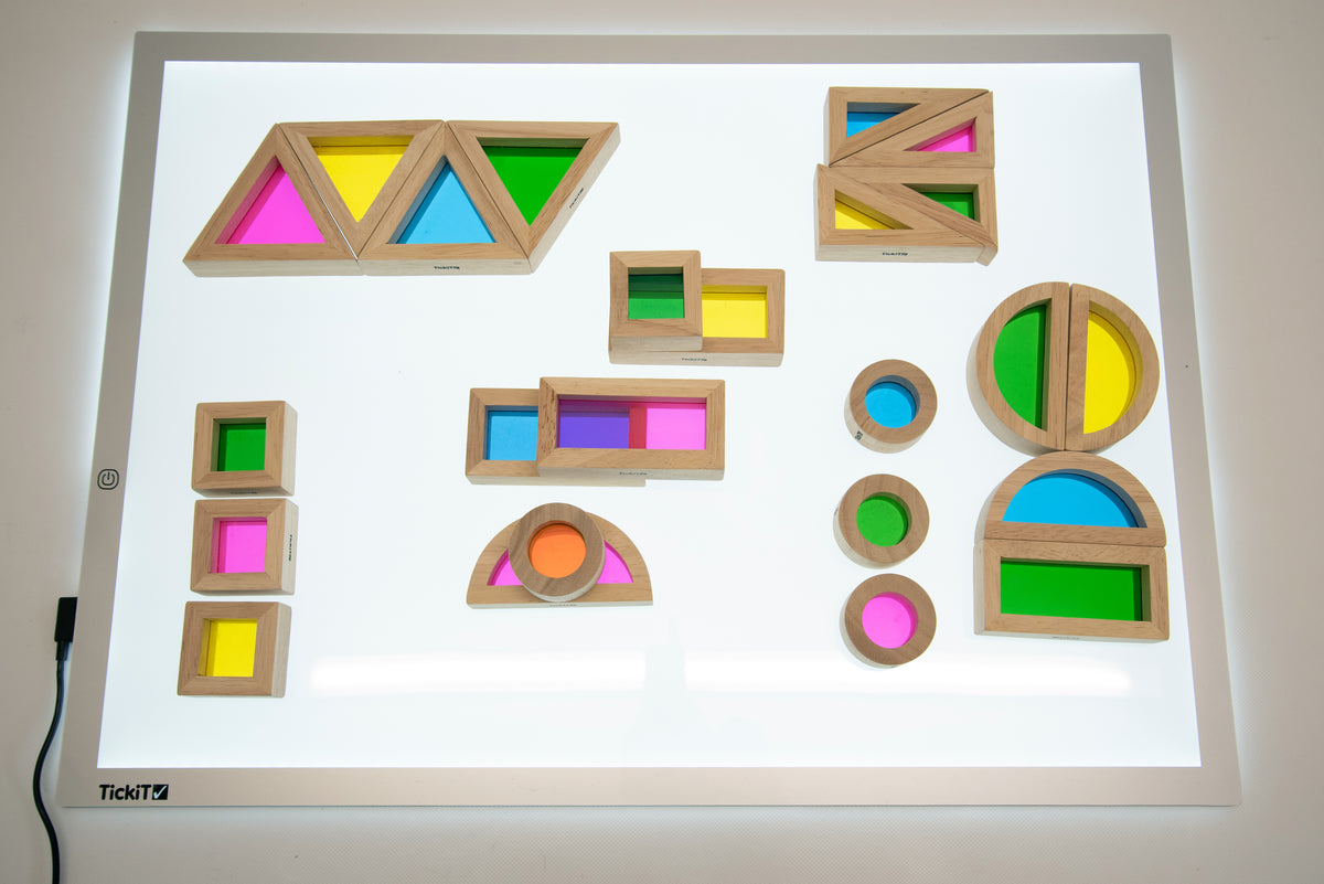 Wooden rainbow block set arranged on tray board with framed cubes, arches, and rings