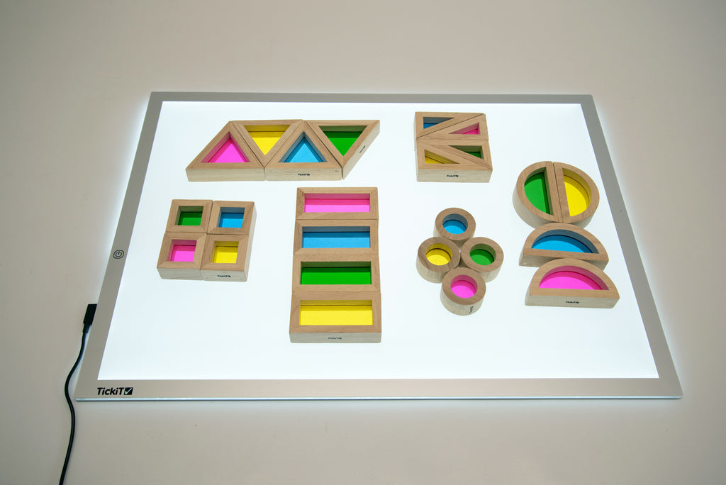 Wooden rainbow block set on light board with rainbow stacked blocks and circular pieces