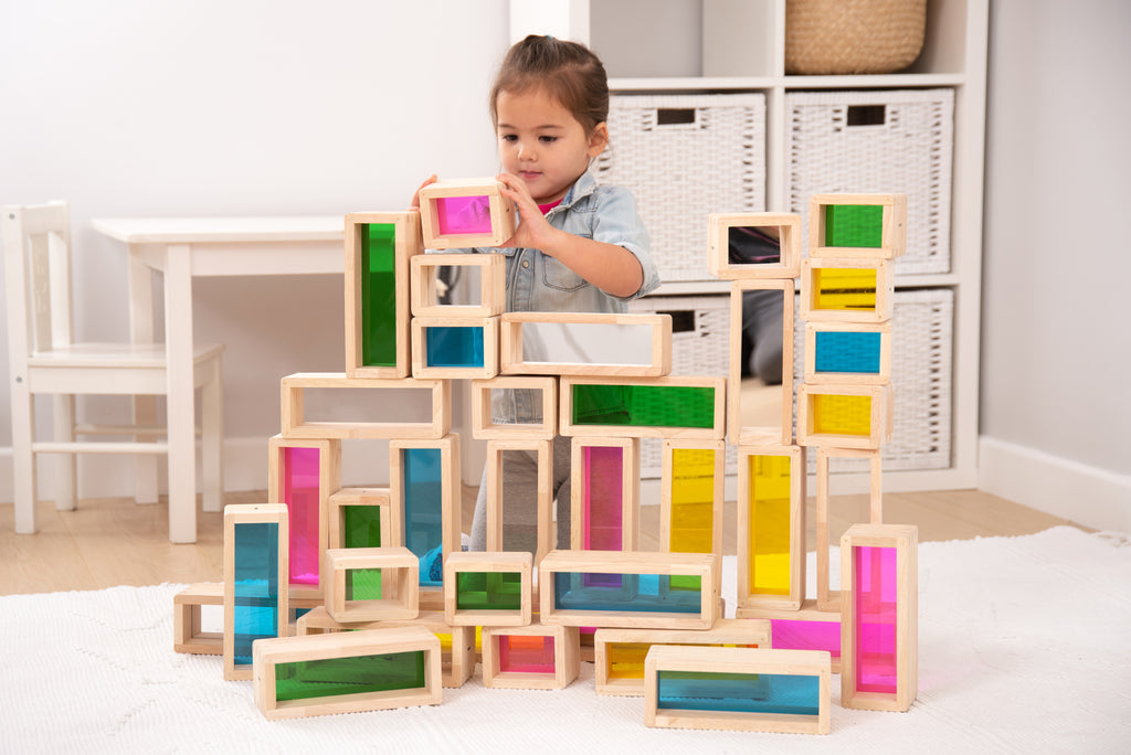 Wooden building block set with rainbow window bricks stacked into a tower