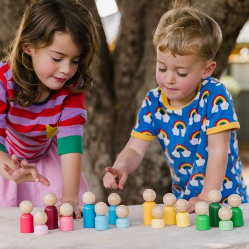 Colorful wooden rainbow family toy pieces with pegged figures on tabletop