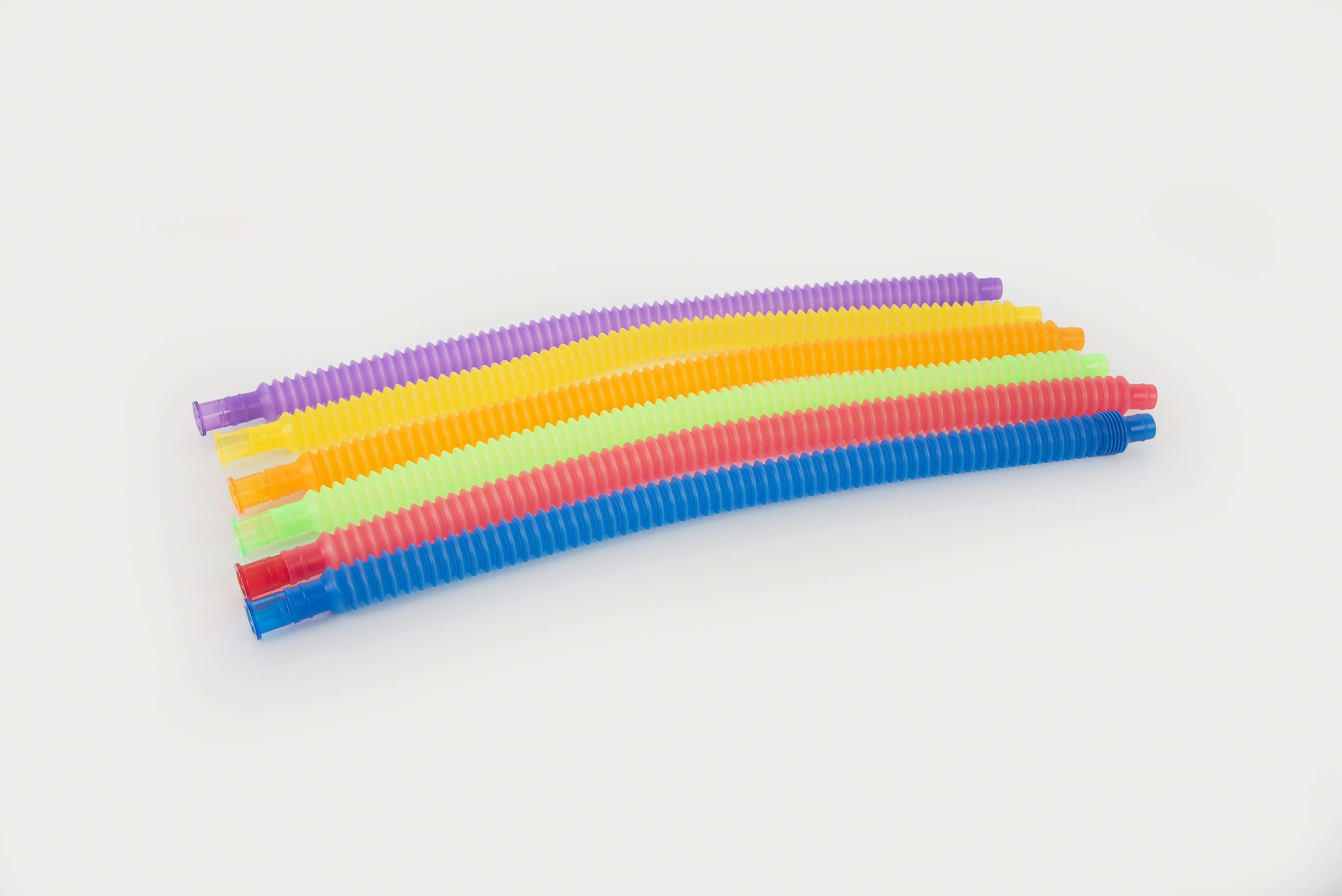 Stacked rainbow flexible tubes with ribbed texture in purple, orange, green, red, blue