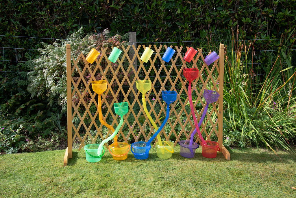 Outdoor display of rainbow flexible tube sprayers and scoop cups on a wooden panel