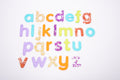 Colorful glitter alphabet letter cutouts arranged on a white background