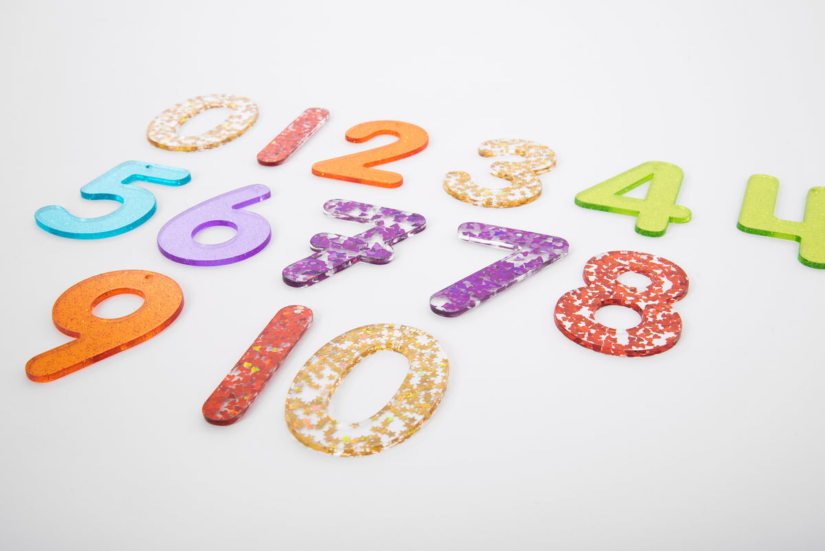 Rainbow glitter number set featuring digits 0–9 in multicolor styles on a white surface