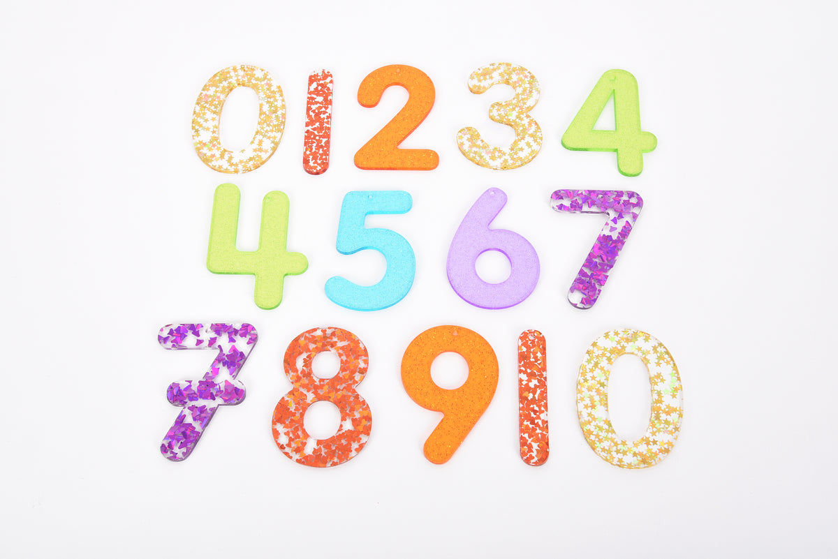 Rainbow glitter number set featuring digits 0–10 in orange, blue, purple, and gold