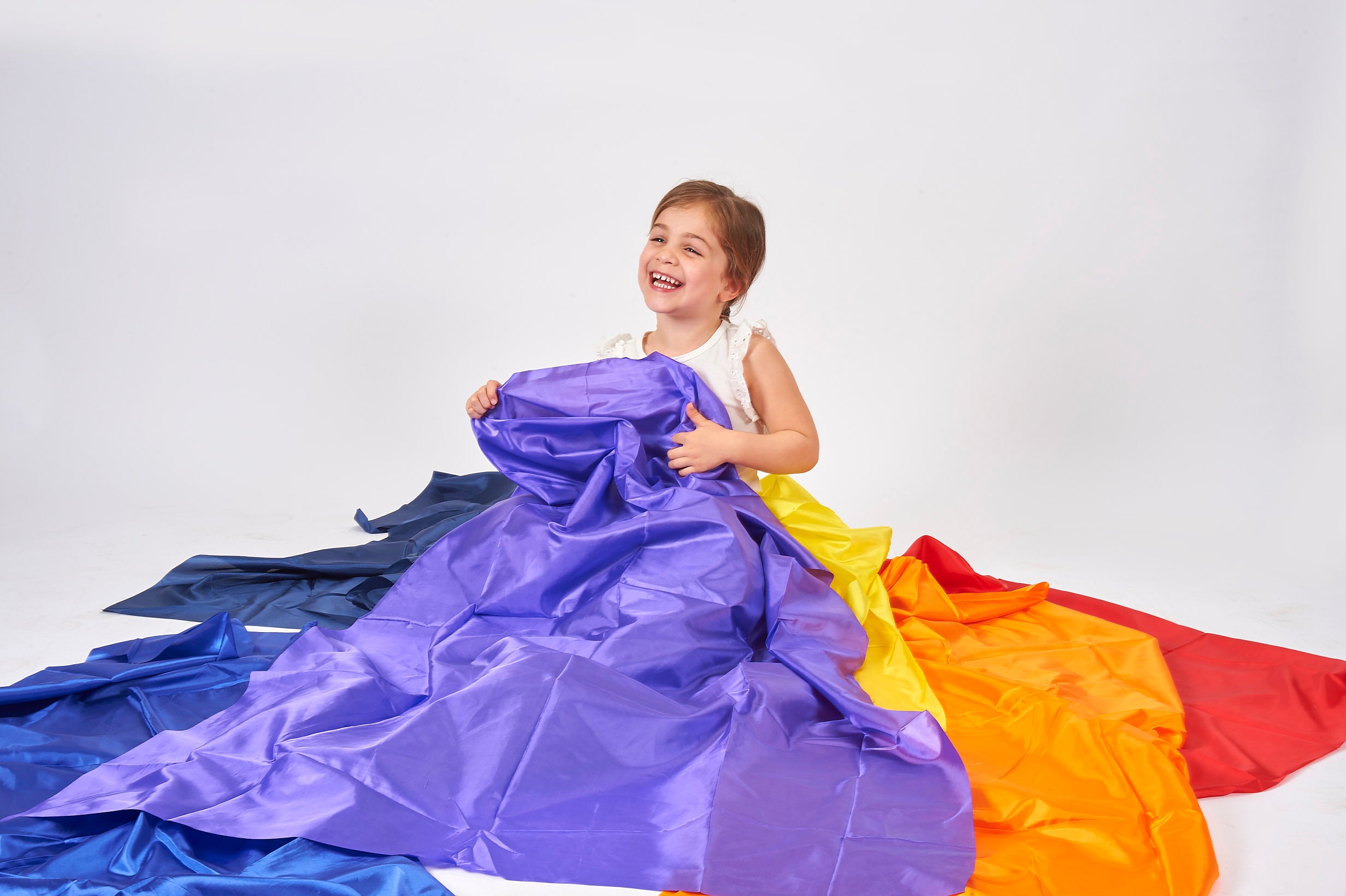 Purple habutae fabric drape over folded blue and orange fabric